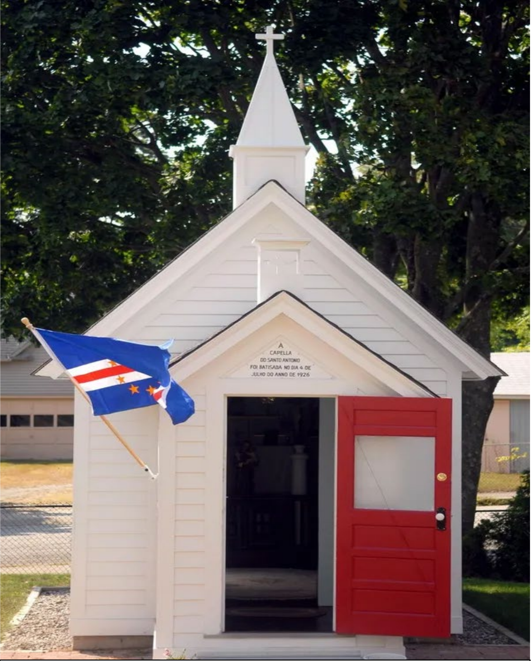 St. Anthony’s Chapel in Norwich with a Cape Verde flag beside its open red door